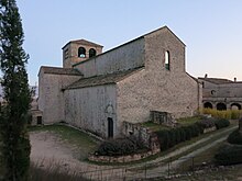 Photographie d'une église romane dans un paysage méditerranéen