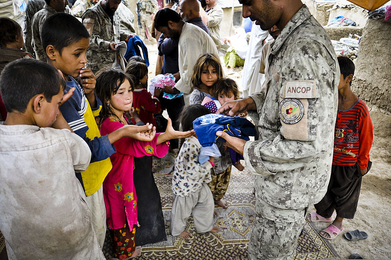 File:An Afghan National Civil Order Police officer hands out clothing donated by a charity in New Jersey to children living at a refugee camp in Kabul, Afghanistan, July 28, 2011 110728-F-AK669-291.jpg