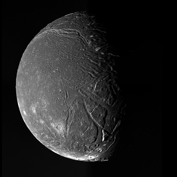 Ariel in greyscale as imaged by Voyager 2 in 1986. Extensive grabens are visible, including the Kachina Chasmata in the upper part of the image.