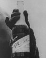 Bottle close-up, Woman with a bottle of Miller Beer in 1921 detail, from- Zion City, Ill., destroys 80,000 pint bottles of beer LCCN88715933 (cropped) (cropped).jpg