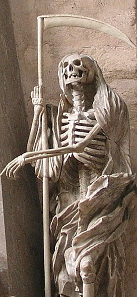 Statue of Death, personified as a human skeleton dressed in a shroud and clutching a scythe, at the Cathedral of Trier in Trier, Germany