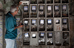 An inspector checking the energy meters in multifamily housing building. Havana (La Habana), Cuba