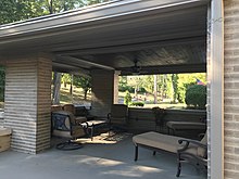 The front porch evokes the Prairie School style that features a connection to the outdoors. Jenet-Roetter House porch.jpg