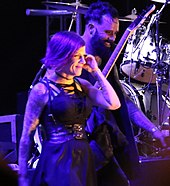 Cooper walking off stage with his wife Korey in 2017 John and Korey Cooper Skillet walking off stage Lifest 2017.jpg
