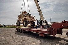 Contractors load an MRAP onto a flatbed as the CJTF-OIR coalition transfers the K-1 Air Base to Iraqi security forces, 21 March 2020 Loading an MRAP at K-1 Air Base, March 2020.jpg