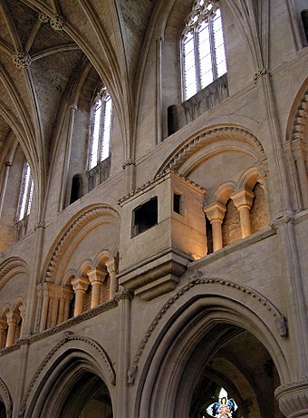 Malmesbury Abbey, Wiltshire, England. The nave wall is divided into three stages: the upper stage with windows is the clerestory, beneath it is the triforium, and the lowest stage is the arcade.