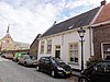 Huis met zadeldak tussen zij-topgevels en met gepleisterde lijstgevel,