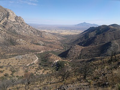 Desert valley vista between mountains, with trail and desert shrubs