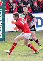 Ronan O'Gara (red) playing for Munster in 2013 O'GaraPassingHeinekenCup(cropped).jpg