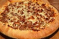 Pizza with sausage, onion, pepperoni, olives and cheeses.jpg
