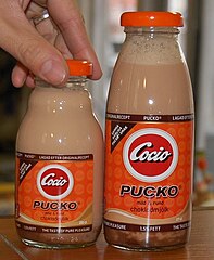 Two glass bottles of Pucko with Cocio branding as well in 2011, one 20 cl bottle to the left and one 27 cl bottle to the right. Pucko med hand.jpg