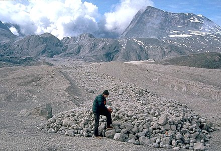 A scientist examines pumice blocks at the edge of a pyroclastic flow deposit from Mount St. Helens