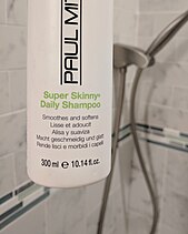 A shampoo bottle labeled with mL first and fl oz second. Note the e estimated net quantity symbol indicates the product also conforms to European Union regulations. Shampoo Net Quantity.jpg