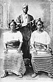 Guinea, circa 1910. A Susu griot poses with his koni (lute) behind two women.