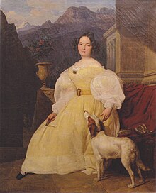 Tableau d'une femme semi-assise, vêtue d'une robe jaune et d'une chemise blanche ayant ses pieds un chien blanc à taches rousses, dans un paysage lointain de montagnes, avec un temple à colonnes de style grec, et un rosier en pot sur un muret.