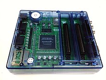 A circuit board and microprocessor in a translucent blue case, with cartridge ports on the right hand side.