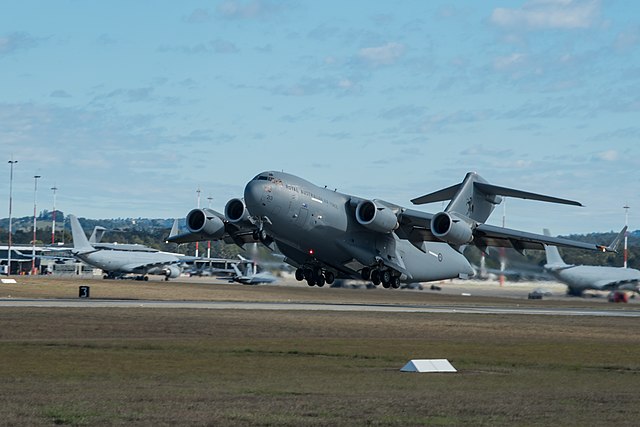 A RAAF C-17 Globemaster III taking off from RAAF Base Amberley, with KC-30 and F/A-18F aircraft in the background