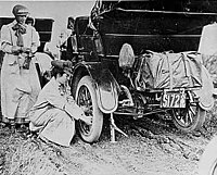 Alice Huyler Ramsey (1887–1983) in 1909, changing a tire on her green Maxwell