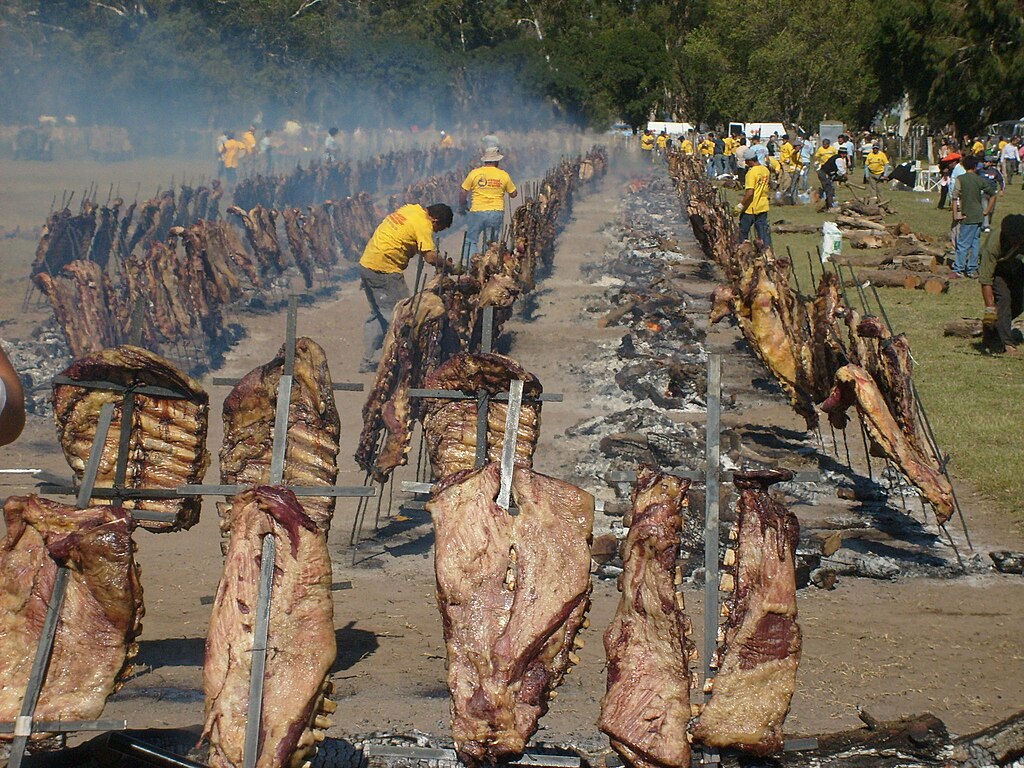 Rows of skewered carcasses roasting above fires on an asado in Patagonia, Argentina