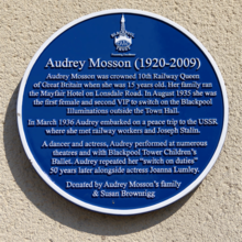 A close up image of the heritage blue plaque dedicated to Audrey Mosson at Lonsdale Avenue. The words read: Audrey Mosson (1920 -2009) Audrey Mosson was crowned 10th Railway Queen of Great Britain when she was 15 years old. Her family ran the Mayfair Hotel on Lonsdale Road. In August 1935 she was the first female and the second VIP to switch on the Blackpool Illuminations outside the Town Hall.In March 1936 Audrey embarked on a peace trip to the USSR where she met railway workers and Joseph Stalin.A dancer and actress, Audrey performed at numerous theatres and with the Blackpool Tower Children’s Ballet.Audrey repeated her ‘switch-on’ duties 50 years later alongside actress Joanna Lumley. Donated by Audrey Mosson’s family & Susan Brownrigg