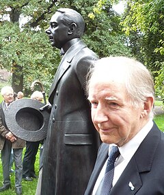 Bure Holmbäck framför statyn av Hjalmar Söderberg vid Kungliga biblioteket.