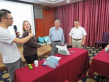 Lisa Moore, vice president of the Unicode Consortium, presenting Choijinzhab and Nashunwuritu with copies of the Unicode Standard at a meeting of ISO/IEC JTC 1/SC 2 in Hohhot, Inner Mongolia, in 2017 Choijinzhab presentation.jpg