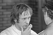 Svart-hvitt-bilde av Chris Amon som holder en sigarett