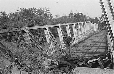De brug bij Lobongkok is vernield, behoedzaam verkent wachtmeester Dorenbal uit Gent de situatie. (Juli 1947)