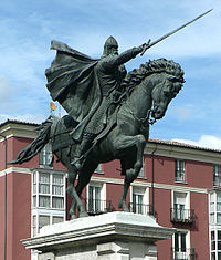 A statue of a man (Alfonso I) on a horse pointing forward with a sword in his right hand.