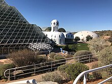 Exterior showing parts of the rainforest biome and of the habitat, with the West lung in the background Exterior of Biosphere 2.jpg