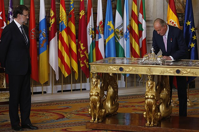 King Juan Carlos I assenting to and enacting a law...