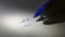 Imagen de puntas de escritura de un bolígrafo de gel y un bolígrafo sobre una hoja de papel junto a las líneas creadas por cada bolígrafo.
