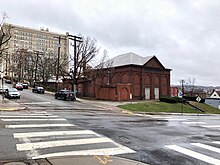 Ein Foto der Herron Hill Pumpstation im Jahr 2019. Es ist ein rotes Backsteingebäude mit zugemauerten Fenstern und einem weißen Dach.