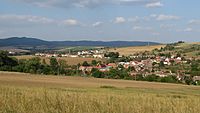 Pohled na obec Hýsly od jihozápadu. V pozadí kopec Bradlo v Chřibech.