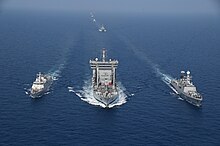 3 ships at sea with an escort convoy trailing, the Shakti is at the center