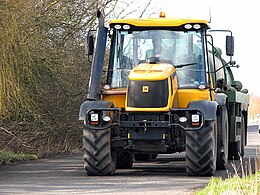 frontaanzicht van gele tractor op de weg