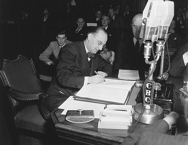 Joseph Smallwood signs the document bringing Newfoundland into Confederation