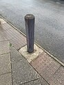 Wooden bollard painted grey, some paint is worn away