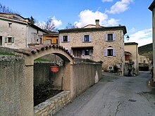 Photographie d'une rue de village avec maisons traditionnelles en pierre.