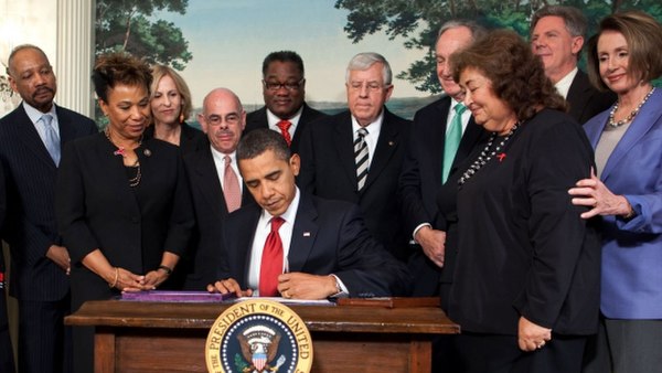 Frank Pallone beside President Obama who signs the Ryan White HIV/AIDS Treatment Extension Act of 2009.
