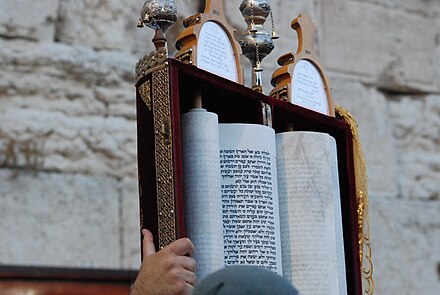A man holds up a Sephardi-style torah at the Western Wall, Jerusalem