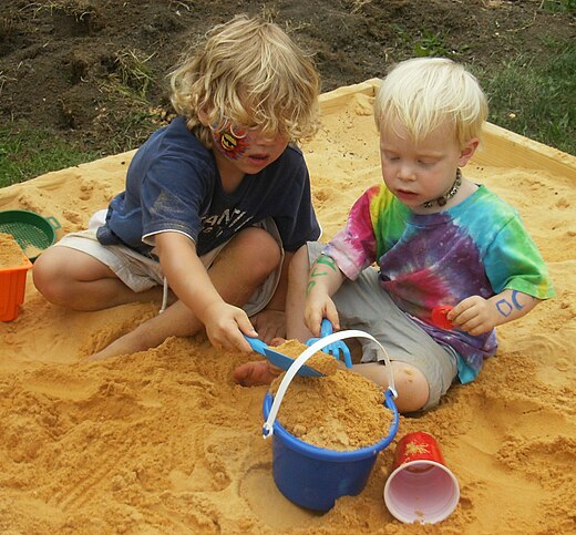 Zandbak met spelende kinderen