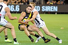 Edwards fending off a tackle from Josh Smith during the AFL round two match between Richmond and Collingwood Smith tackling Edwards.jpg