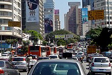 Hình ảnh từ trên cao của một con đường đông đúc, hai bên được bao quanh bởi các tòa nhà cao tầng, một số trong số đó được phủ bởi bảng quảng cáo.