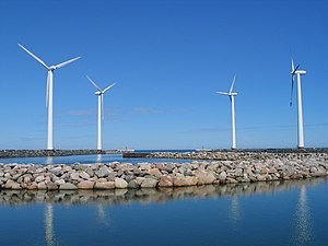 Four wind turbines located at sea.