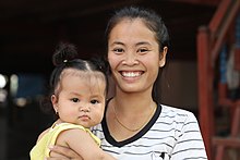 An infant with her mother, a possible attachment figure Young mother smiling while holding her baby in Laos.jpg