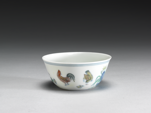 a tiny porcelain wine cup painted with chickens, cocks and hens