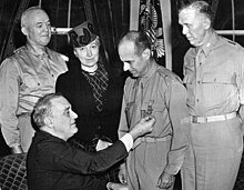 Doolittle received the Medal of Honor in 1942 from President Roosevelt in a ceremony attended by (standing, L-R) Lt. Gen. H. H. Arnold, Josephine Doolittle, and Gen. George C. Marshall. 208-PU-52-LL-12 (34371208606).jpg