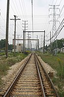 Transition zone of third-rail to overhead-wire supply on Chicago's Yellow Line (the "Skokie Swift"), shown shortly before the conversion to third rail operation in September 2004. 3rd rail to overhead wire transition zone on the Skokie Swift.jpg