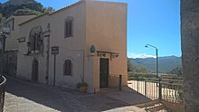 Prospetto della casa medievale con la bifora (XV secolo). Sullo sfondo l'Etna innevato e fumante.